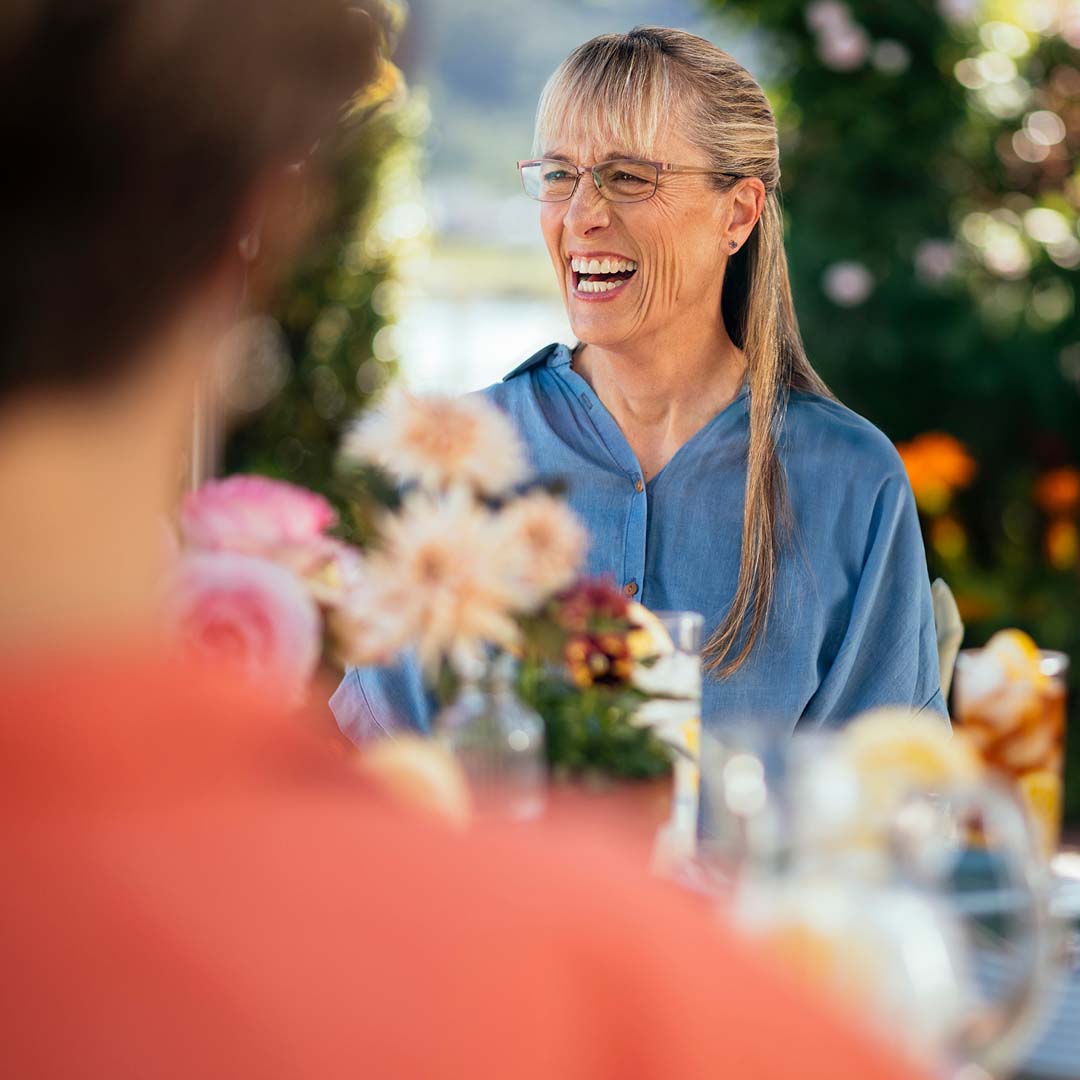 Woman enjoying conversation outdoors at a table