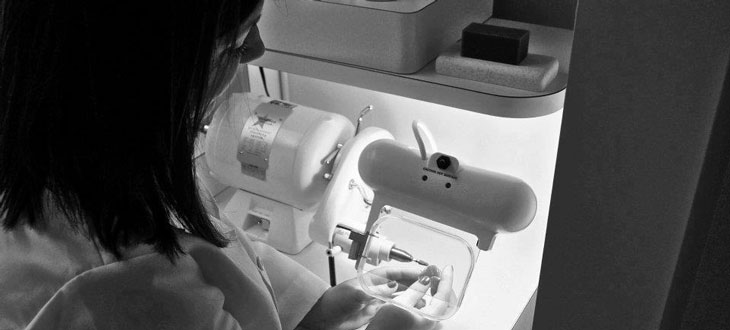 Amy Holland works on a hearing aid. 